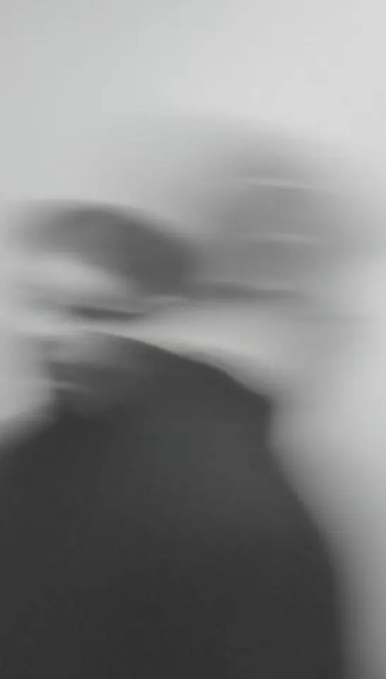 Motion-blurred profile of a person in a crowded hall